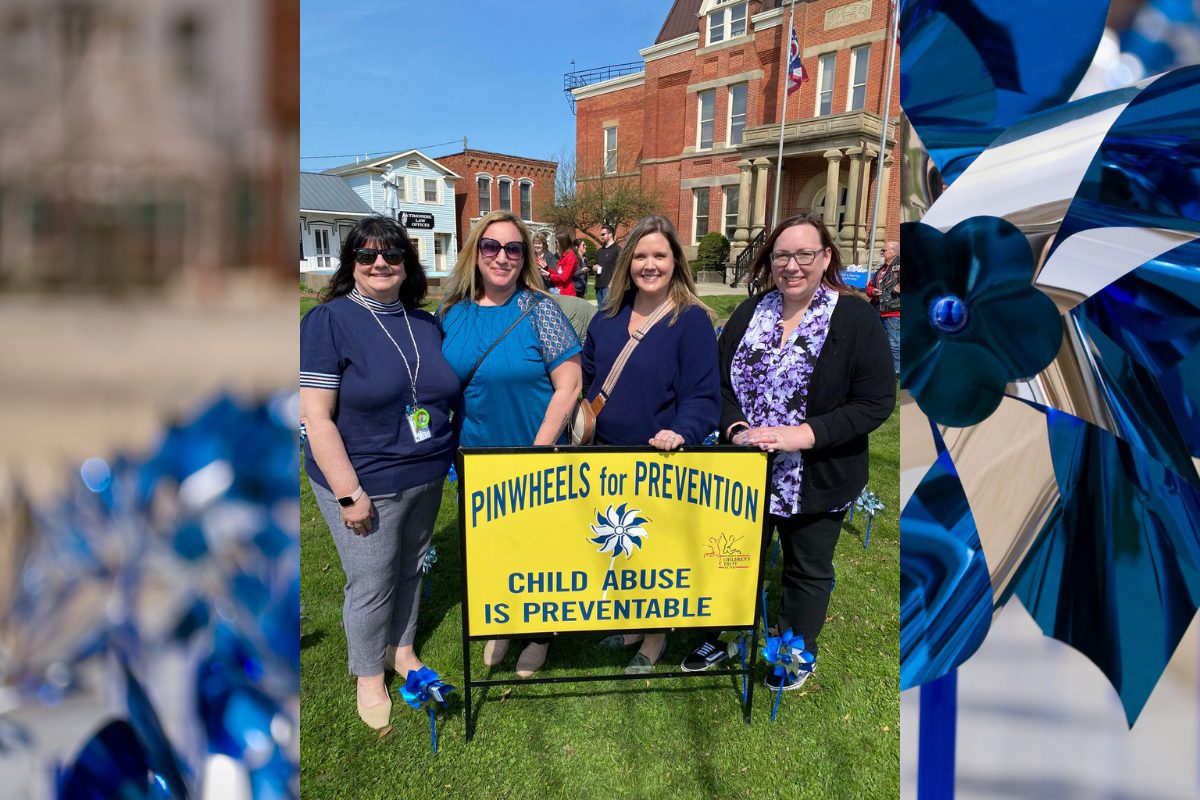 Four women in front of the courthouse holding a sign pinwheels for prevention, child abuse is preventable